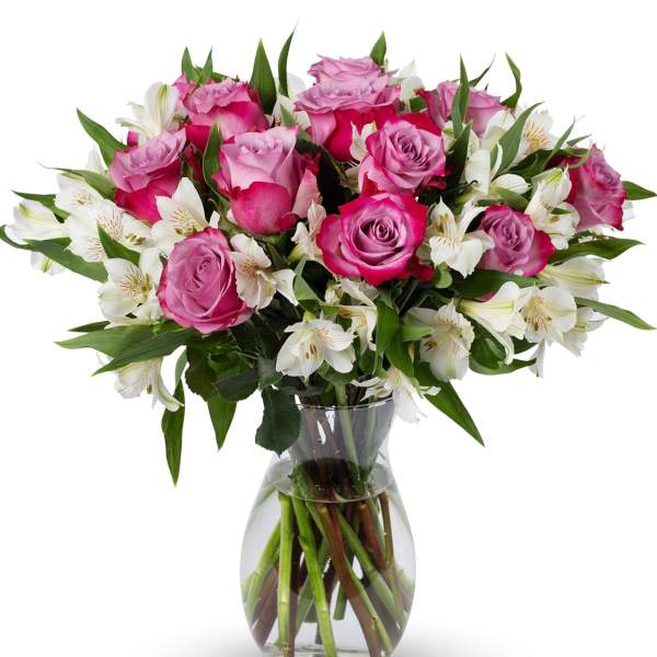 Pink roses and white alstroemeria in a clear glass vase