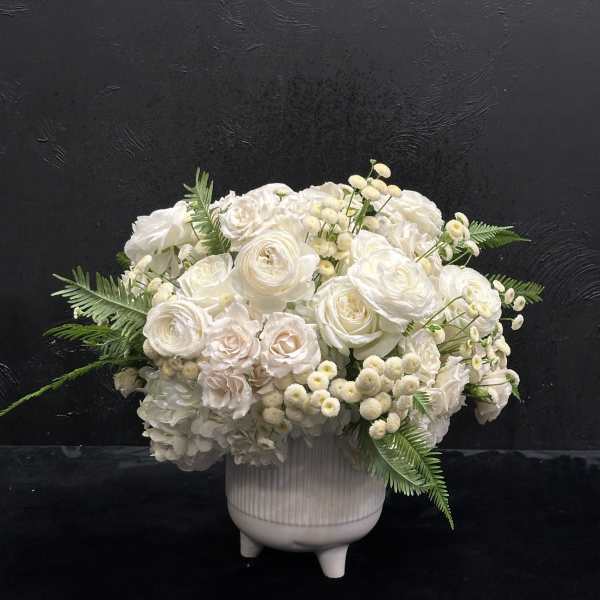 White floral arrangement in a ribbed ceramic vase