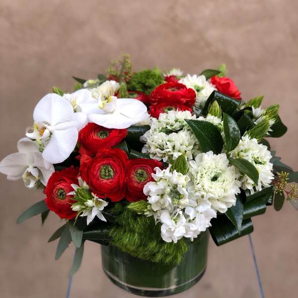 Red and white floral arrangement in a green vase