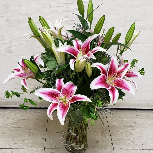 Pink stargazer lilies arranged in a clear glass vase