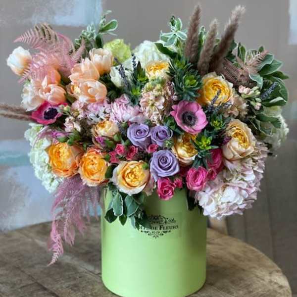 Mixed pastel bouquet in a green hatbox