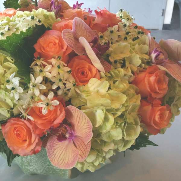 Bouquet of orange roses and pale hydrangeas in a vase