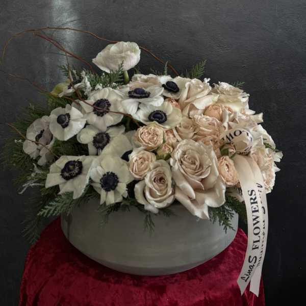 Cream and blush roses with white anemones in a round vase
