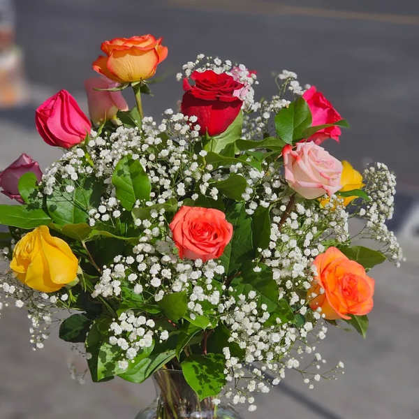 Mixed roses in a clear glass vase with baby's breath