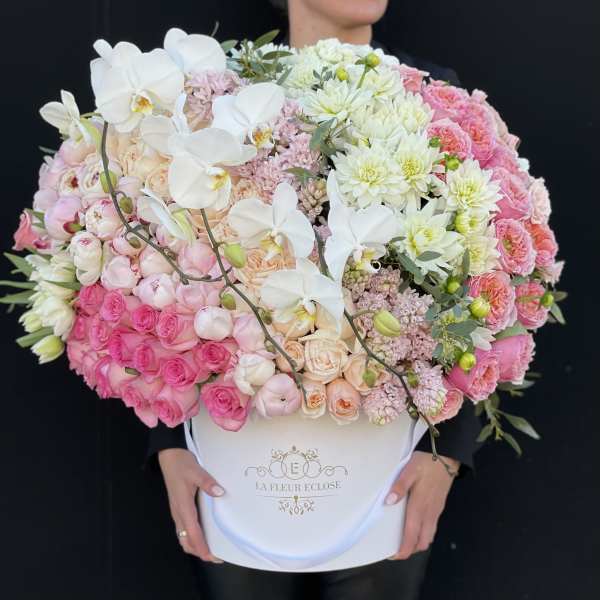 Large pink and white flower arrangement in a white hatbox