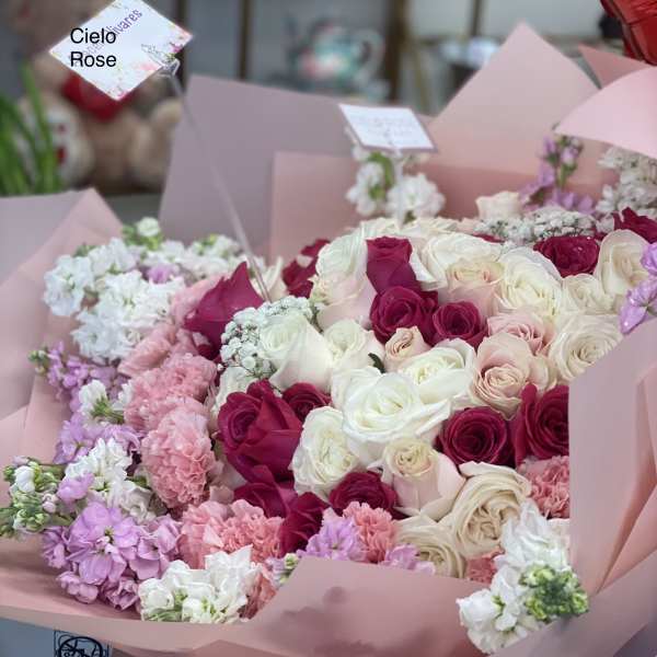 Pink and white rose bouquets with carnations in pastel wrapping