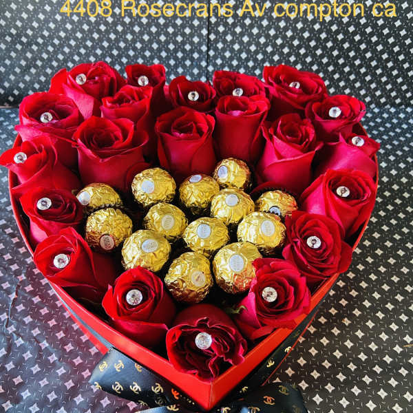 Heart-shaped box of red roses with gold-wrapped chocolates and a ribbon bow