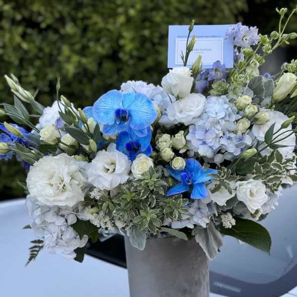 Blue and white floral arrangement in a gray vase