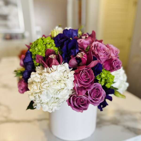 Bouquet of purple and white flowers in a white vase