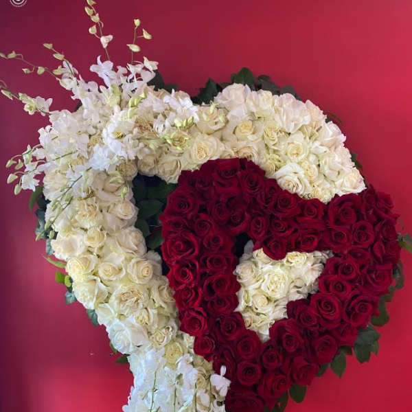 Heart-shaped floral tribute of red and white roses on an easel