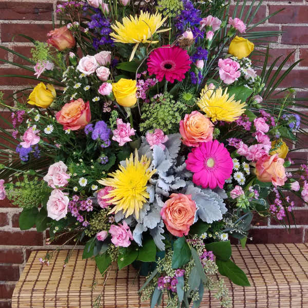 Large mixed bouquet with roses, gerbera daisies, and purple blooms