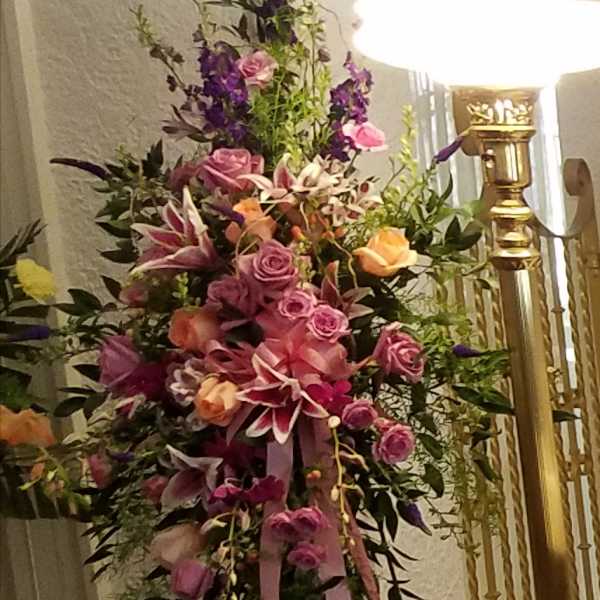 Tall floral spray with pink and purple flowers on a stand