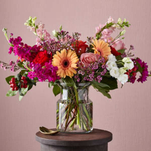 Mixed bouquet in a clear glass vase with pink, red, and white flowers