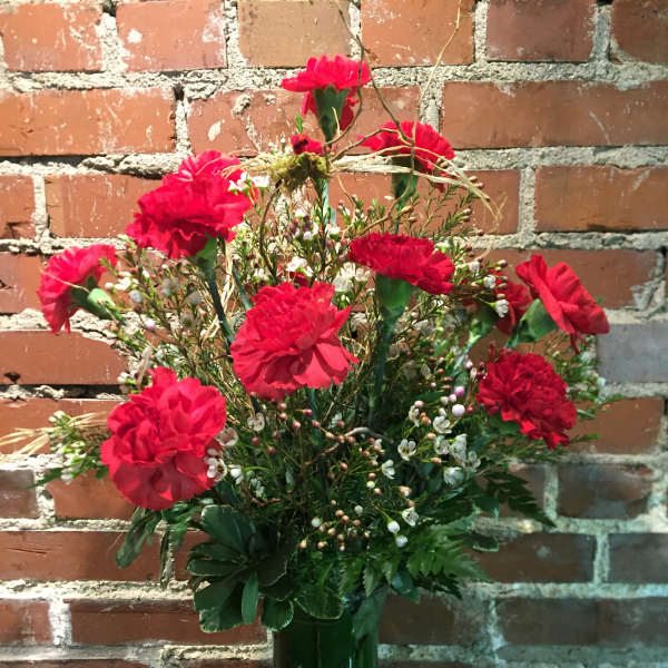 Red carnations in a green glass vase