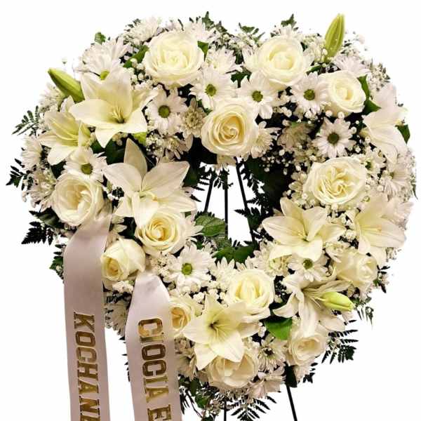 Heart-shaped white floral wreath with roses, lilies, and daisies