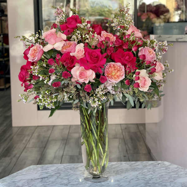 Large bouquet of pink and red roses in a clear glass vase