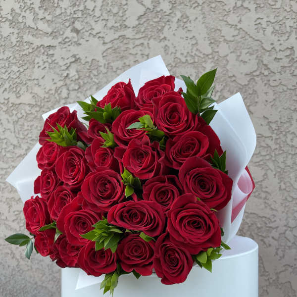Bouquet of red roses wrapped in white paper