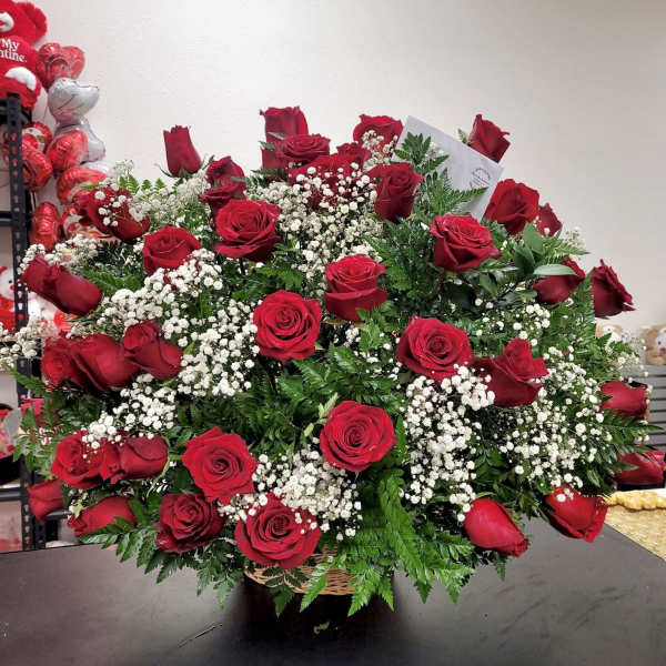 Large bouquet of red roses with white baby's breath in a basket