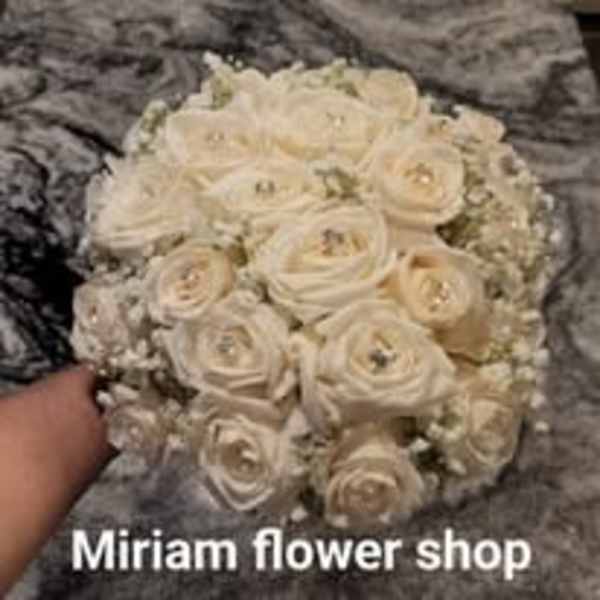 Cream rose bouquet with baby's breath on a gray surface