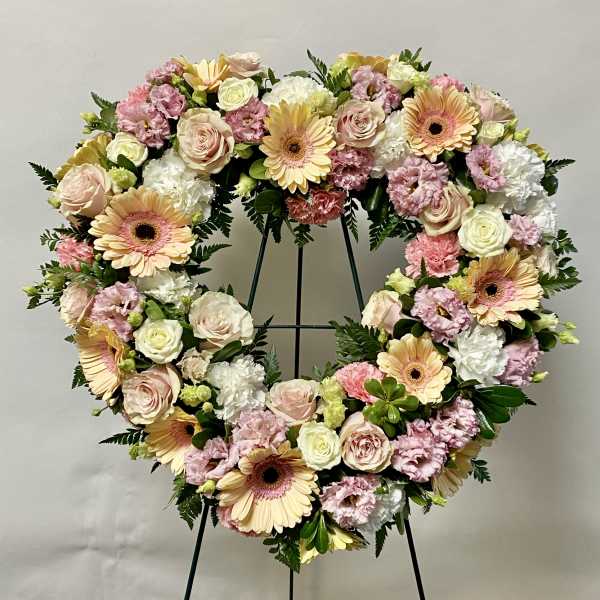 Heart-shaped floral wreath with pink, cream, and peach flowers