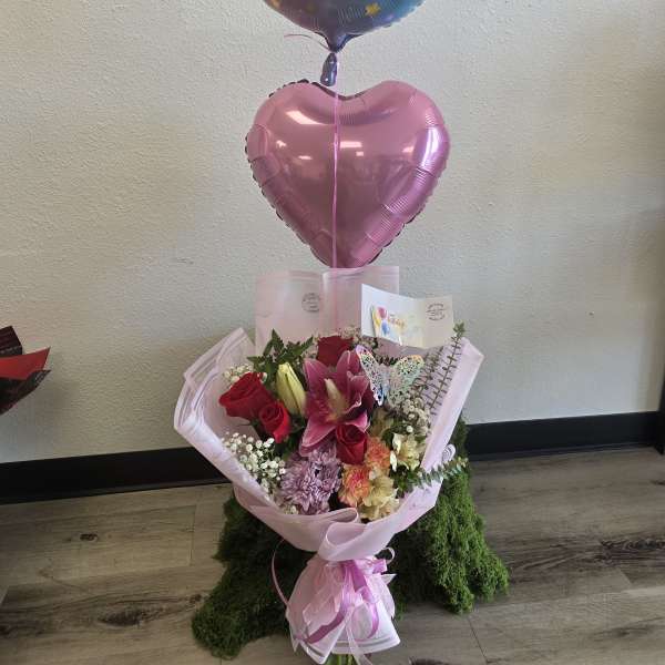 Bouquet of pink and red flowers with birthday balloons