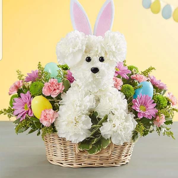 White flower bunny in a wicker basket with pastel flowers and eggs