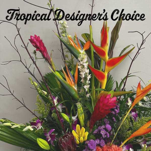 Tall tropical flower arrangement with orange, red, purple, and yellow blooms and bold foliage