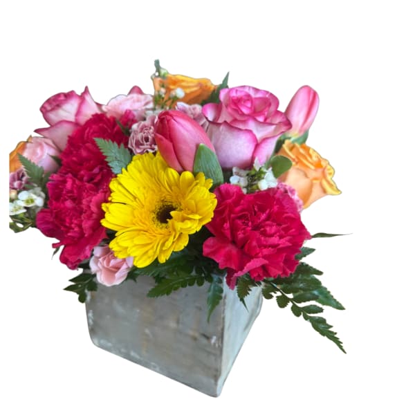 Mixed pink and yellow flowers in a square metal vase