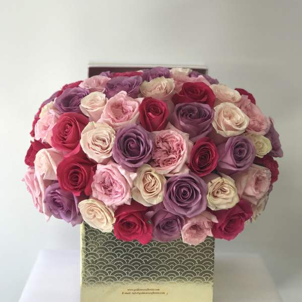 Boxed bouquet of pink, purple, and cream roses