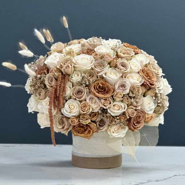 Bouquet of cream and beige roses in a round vase
