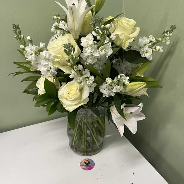 White lilies and roses arranged in a glass vase