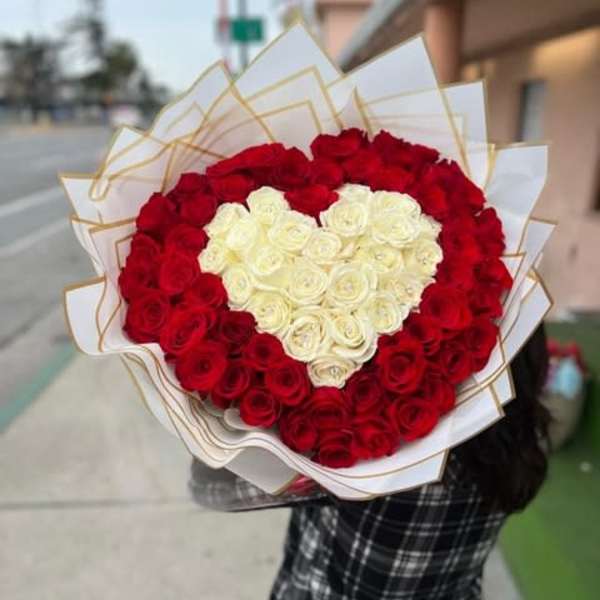 Heart-shaped bouquet of red and white roses wrapped in white paper