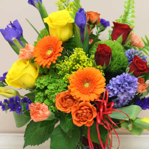Colorful mixed bouquet with roses, gerbera daisies, and purple blooms