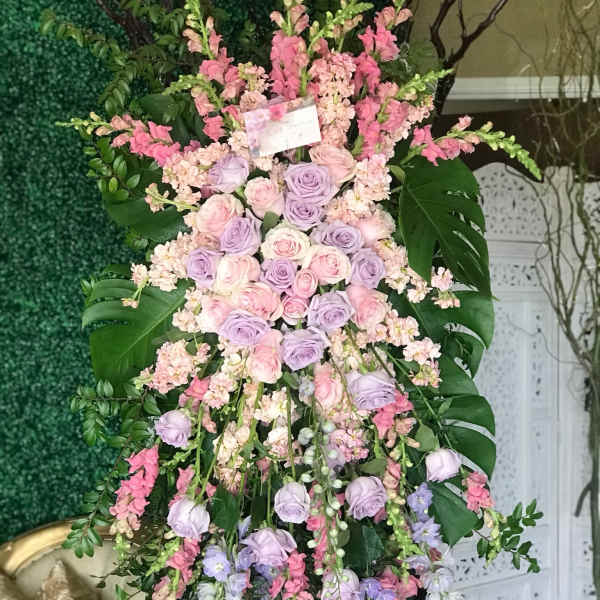 Tall pastel floral standing arrangement with roses and cascading blooms