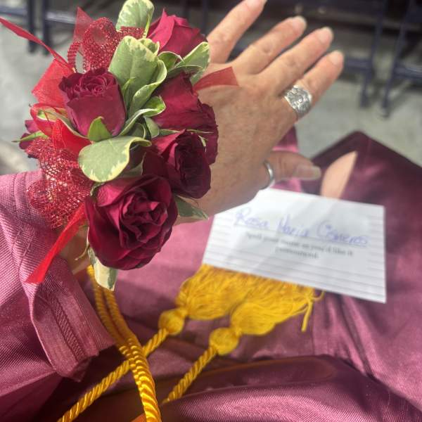 Small wrist corsage with deep red roses and ribbon