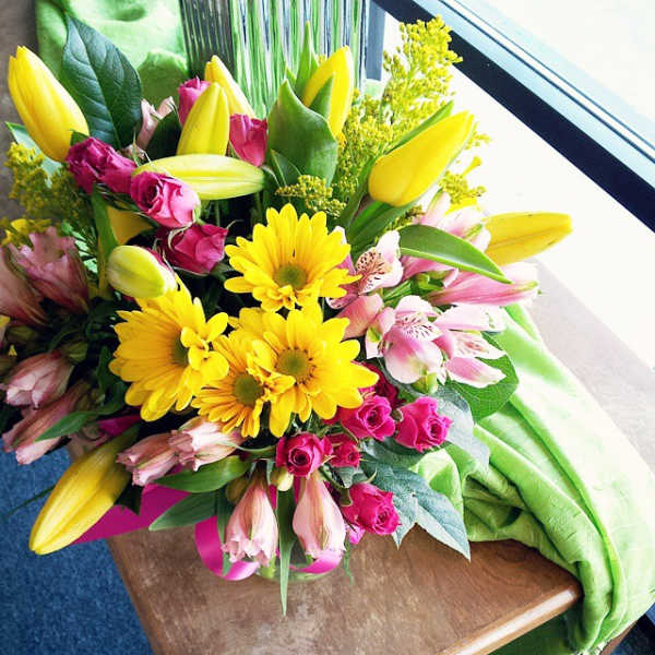Bouquet of yellow lilies, pink roses, and yellow daisies
