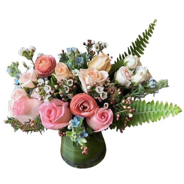 Pink and peach roses with ranunculus in a green vase