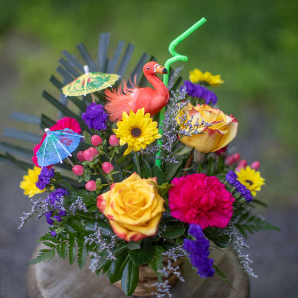 Tropical bouquet with roses, sunflower, carnation, and flamingo decoration