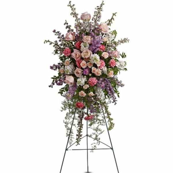 Tall standing floral spray with pink and lavender flowers on a metal easel