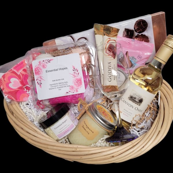 Gift basket with wine, chocolates, bath items, and candles