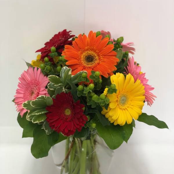 Colorful gerbera daisy bouquet in a clear glass vase