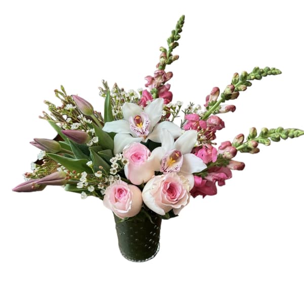 Pink roses, white orchids, and pink snapdragons arranged in a green textured glass vase