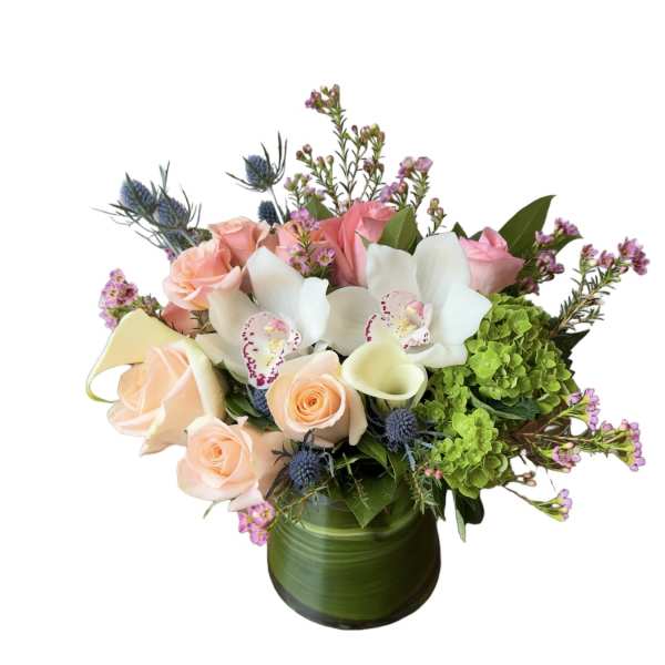 Bouquet of pink roses, white orchids, and green hydrangeas in a green vase