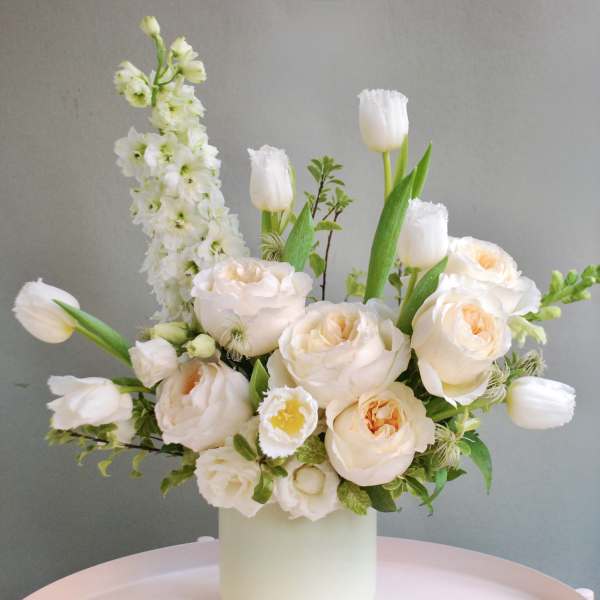 Cream bouquet with tulips and roses in a white vase