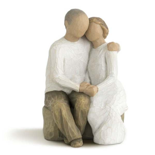 Wooden figurine of a seated couple embracing