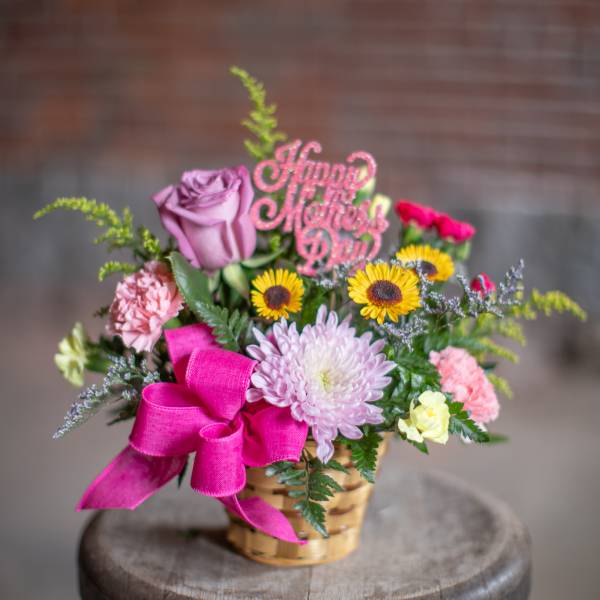 Basket arrangement with pink and purple flowers and a Happy Mother's Day pick