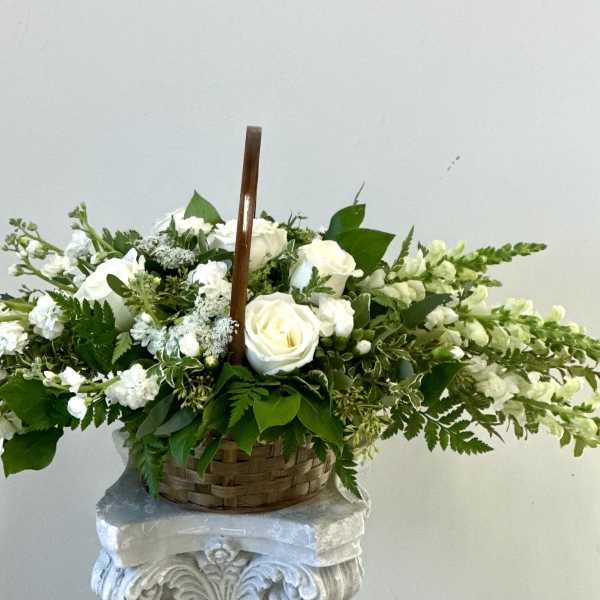 White roses and snapdragons in a woven basket