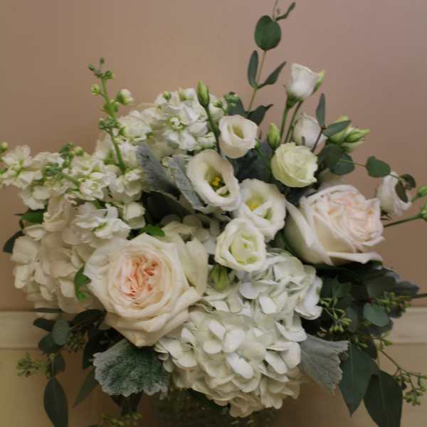White roses and hydrangeas in a dark vase