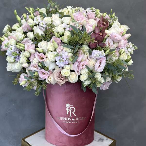 Large pastel bouquet of roses and lisianthus in a pink hatbox