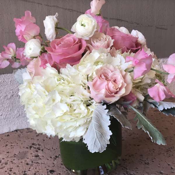 Pink and white floral arrangement in a glass vase